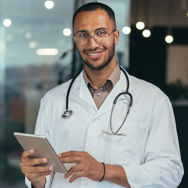 doctor smiling and holding tablet