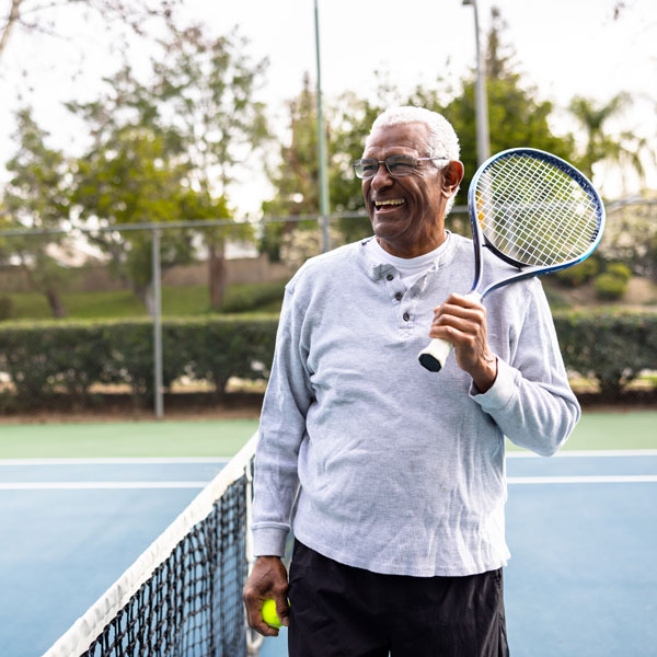 smiling mature man on tennis court